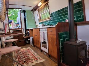 伦敦Unique Canal Boat in London Centre for Family & Friends的厨房配有炉灶和绿色瓷砖