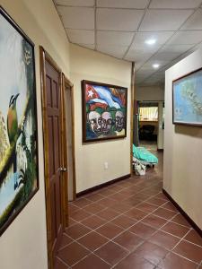 希门尼斯港Casa Manglar Villa的墙上的走廊和瓷砖地板上都装饰有绘画作品