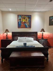 希门尼斯港Chosa Manglar Suites的一间卧室配有一张床、两盏灯和一幅画