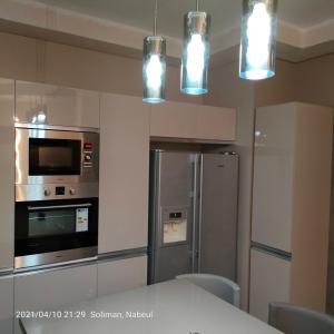 纳布勒Tiba soliman plage的厨房配有不锈钢冰箱和灯