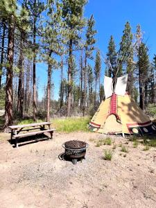 ChiloquinHeartline Ranch, LLC的帐篷和野餐桌旁的烧烤架