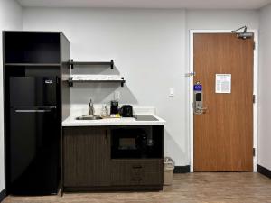 奥格登Studio 6 Ogden, UT 21st Street的厨房配有水槽和黑冰箱。