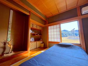 本宫Villa KUMANO的一间卧室设有蓝色的床和窗户。
