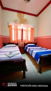 亚奎巴Residencial Guzmán 1的红色和白色墙壁的客房内的两张床