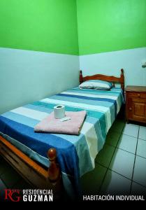 亚奎巴Residencial Guzmán 1的一间卧室设有两张带蓝色和绿色墙壁的床。