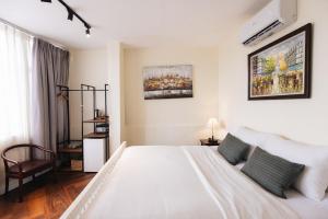 胡志明市9 Hostel and Suites的白色卧室配有床和椅子