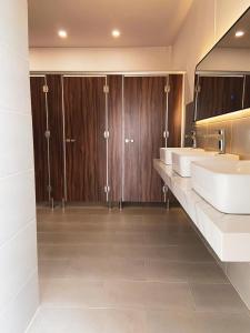 胡志明市9 Hostel and Suites的一间带两个盥洗盆和木制橱柜的浴室