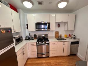 纽约Studio room的厨房配有白色橱柜和不锈钢炉灶。