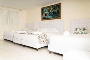 金巴亚FINCA HOTEL LA QUINTA DE TORRIONE的墙上画有两张白色的床