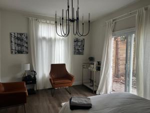 多伦多Sweet Home的一间卧室配有一张床、一把椅子和一个吊灯。
