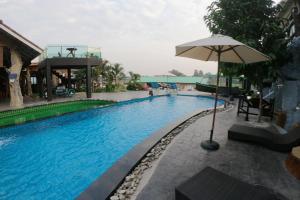 Chai NatSuwanna Riverside的一座带遮阳伞的游泳池位于大楼旁