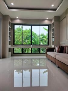 Suen PhraHana Villa Hatyai的带沙发和大窗户的客厅
