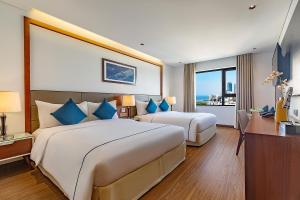 岘港Pavilion Hotel Da Nang的酒店客房设有两张床和窗户。
