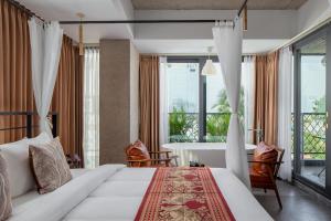 金边CHECK inn Phnom Penh Royal Palace的卧室配有一张床和一张桌子及椅子