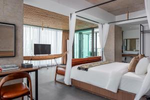 金边CHECK inn Phnom Penh Royal Palace的一间卧室配有一张床、一张书桌和一台电视