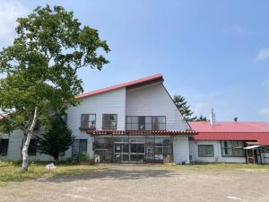 弟子屈町Mashuko Youth Hostel - Vacation STAY 01026v的一座白色的大建筑,有红色的屋顶