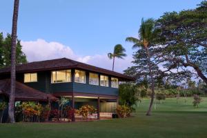 拉海纳Royal Lahaina Resort & Bungalows的前面有棕榈树的房子