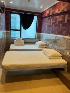 香港3D Inn Hong Kong Romance的带窗户的客房内的三张床