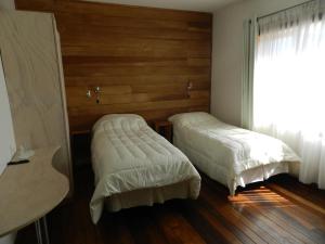 瓦尔迪维亚绿香酒店的一间卧室设有两张床和窗户。