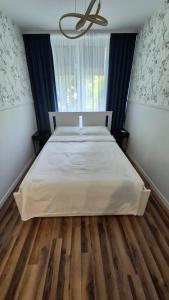 弗沃茨瓦韦克South House的卧室铺有木地板,配有白色的床。