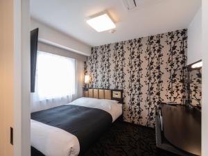 大阪APA Hotel Namba Shinsaibashi Higashi的一间小卧室,配有床和窗户