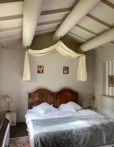 索尔格河畔利勒Maison d'hôtes Campagne-Baudeloup的一间卧室配有一张大床和木制床头板
