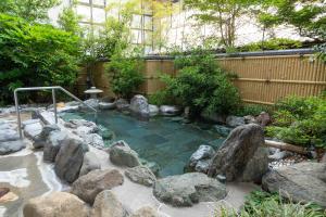 松本浅间温泉和泉莊日式旅馆的花园中小池塘的岩石