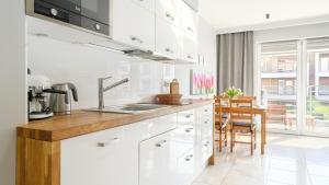 米泽德沃兹Apartamenty Sun & Snow Wasterplatte的白色的厨房配有水槽和桌子