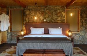 OlolaimutiekAlama Camp Mara的卧室配有一张石墙内的大床