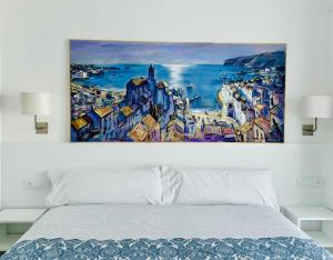 卡达克斯卡达克斯滨海旅馆的卧室内床上的绘画