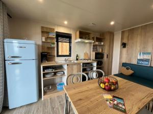 多吕多勒龙Camping Ostréa ****的厨房配有白色冰箱和桌子
