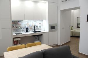 加的斯Torre Solana 41的厨房配有白色橱柜和桌椅