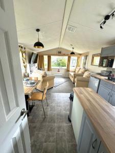 斯凯格内斯Revamped & Upgraded 6 Berth Static Caravan on Southview Skegness的一间厨房和客厅,客厅配有大篷车内的桌子