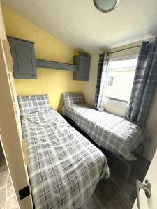 斯凯格内斯Revamped & Upgraded 6 Berth Static Caravan on Southview Skegness的小房间设有两张床和窗户