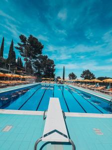 维拉诺瓦达尔本加科瑞尤娜沃尔特露营酒店的游泳池前面设有长凳