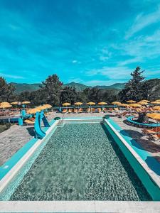 维拉诺瓦达尔本加科瑞尤娜沃尔特露营酒店的一个带水滑梯、椅子和遮阳伞的游泳池