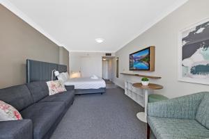 悉尼Comfy Studio Next to Chatswood Station的客厅配有沙发和1张床