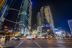 成都晚风酒店(春熙路太古里店)的繁忙的城市街道,晚上有汽车和建筑