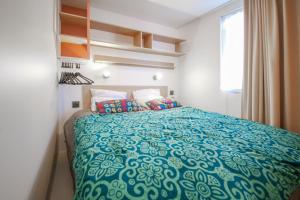 HenxelCamping het Wieskamp的一间卧室配有一张带蓝色棉被的床