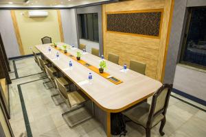 加尔各答Pallavi International的一间会议室,配有长桌子和椅子