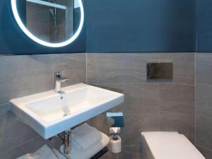 克劳利ibis Styles London Gatwick Airport的一间带水槽、镜子和卫生间的浴室