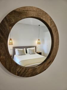 Eira do ChãoParaíso Azul的卧室配有大圆镜壁面