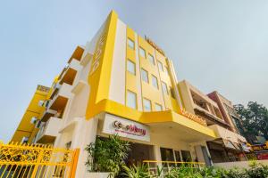 新德里Bloom Hotel - GK2的黄色和白色的建筑,上面有标志