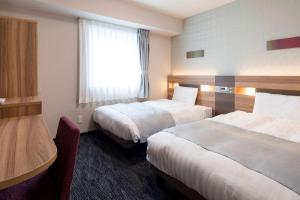 东京东京东神田舒适酒店(Comfort Hotel Tokyo Higashi Kanda)的酒店客房设有两张床和窗户。