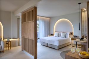 马斯蒂查里Ammos Luxury Resort的配有一张床和一张书桌的酒店客房