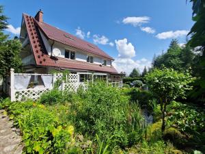 维尔卡瑟Haus Oberberg - Pokoje Ozonowane的一座红色屋顶的房子和一个花园