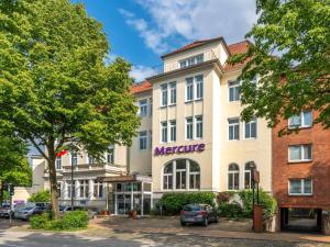 吕贝克Mercure Hotel Luebeck City Center的一座白色的大建筑,上面有细微的标志