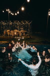 亚列姆切Poderey Villas的一群人晚上在游泳池里