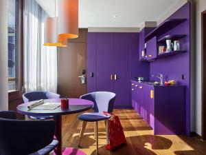 苏黎世苏黎世西区25时酒店的厨房配有紫色橱柜和桌椅