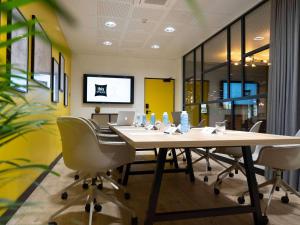 德勒ibis Styles Dreux Centre Gare的一间会议室,配有长桌子和椅子